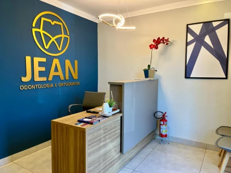 Recepção da clínica do Dr. Jean, com o logotipo na parede