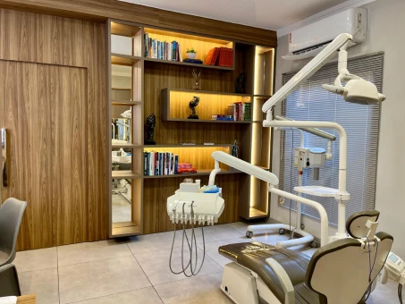 Consultório com cadeira odontológica e armários planejados